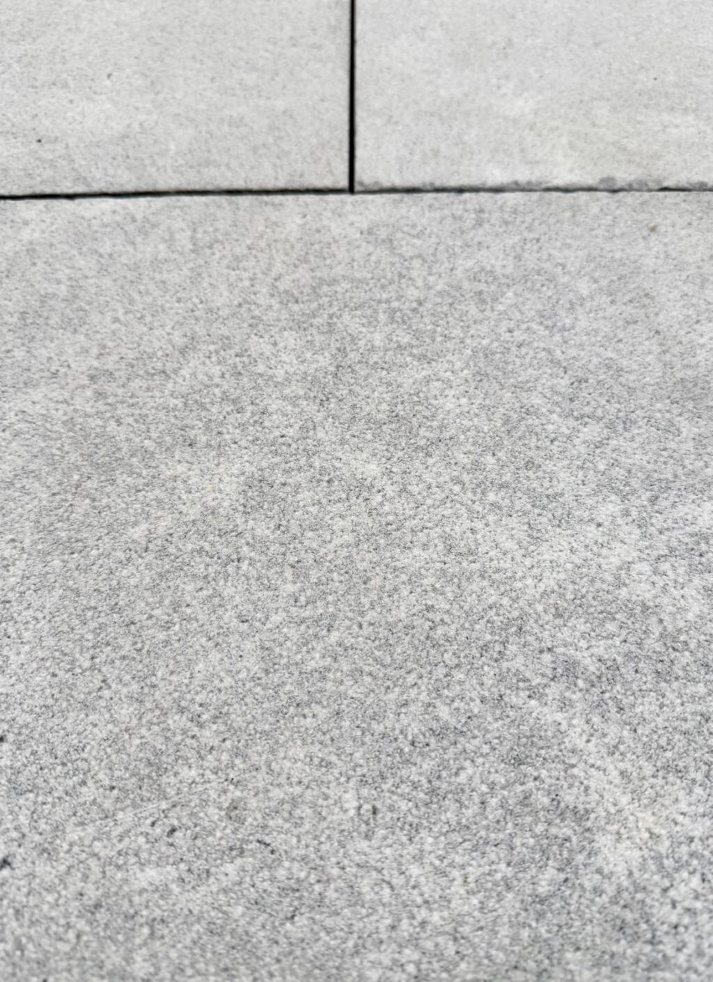 Close-up of Provincial Marble pavers with a soft, speckled grey finish.