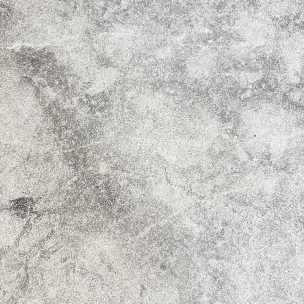 Close-up of Ocean Grey Marble with textured grey tones and soft, cloudy veining.