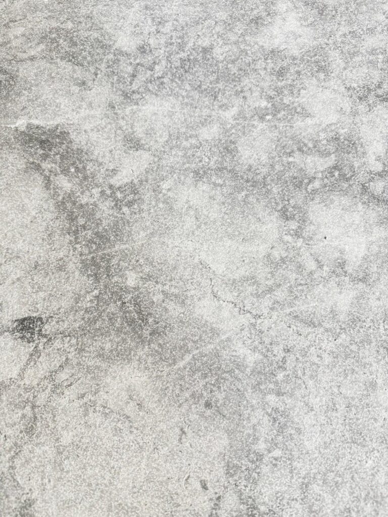 Close-up of Ocean Grey Marble with textured grey tones and soft, cloudy veining.