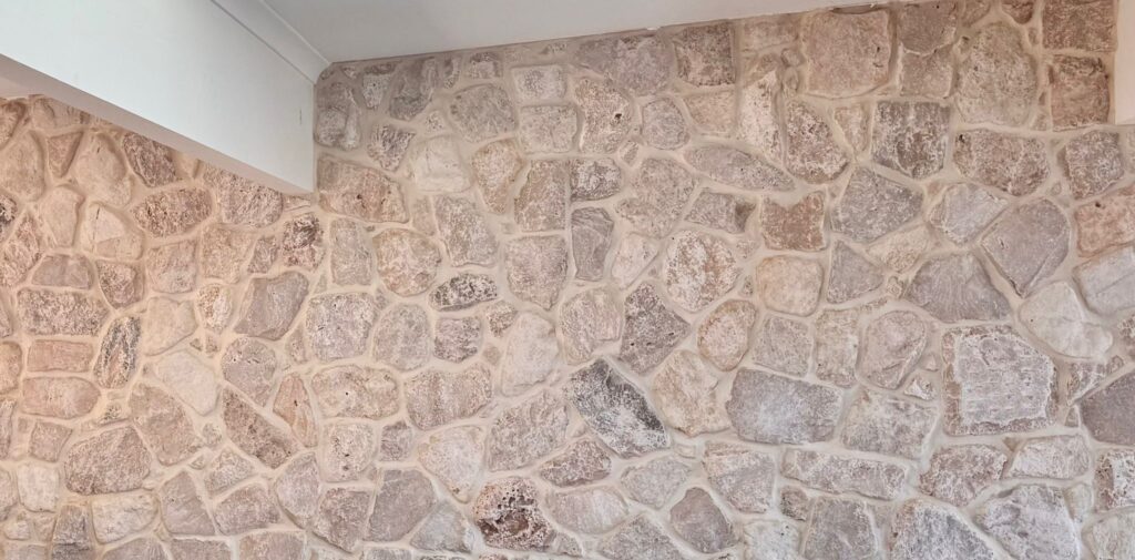Sorrento natural stone wall cladding featuring irregular-shaped stones in soft beige and grey tones with a rustic, textured finish