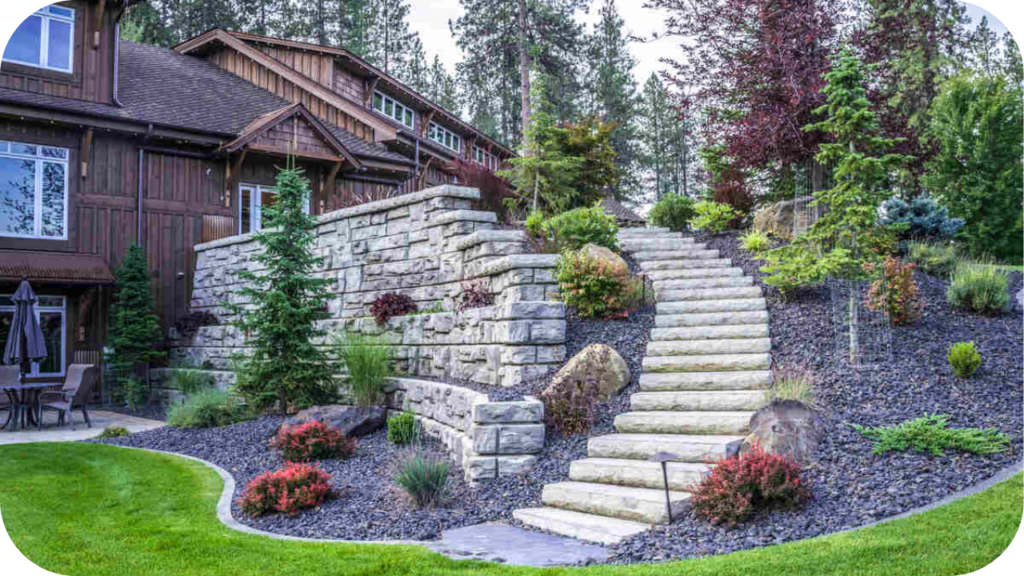 Grand stone retaining wall with wide stairs, evergreens, and landscaped garden beds surrounding a timber-style home exterior.