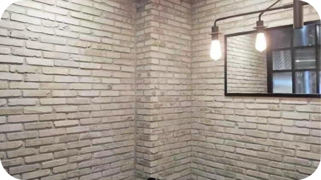Interior corner with Ashbury brick walls, industrial-style light fixture, and black-framed mirror adding charm to contemporary design spaces.