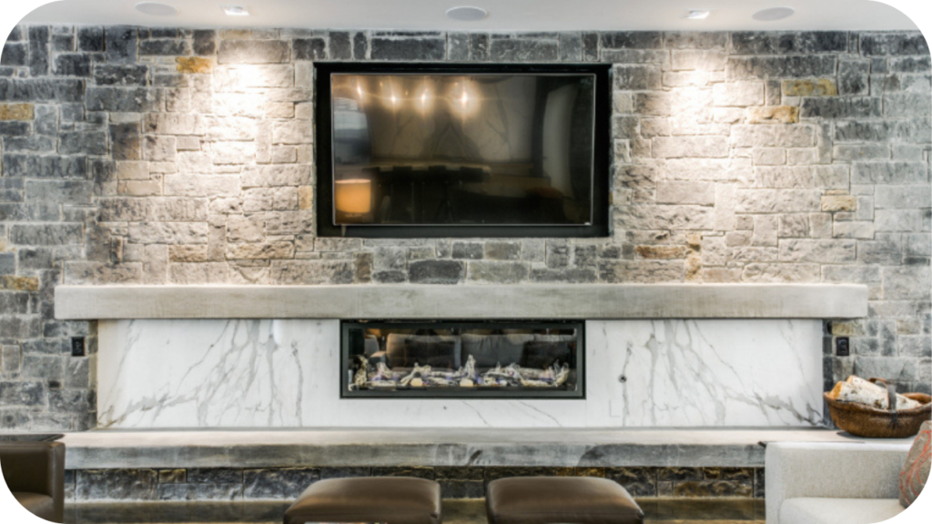 Living room stone fireplace with marble hearth and built-in firebox, paired with mounted TV to create a modern luxury feature.