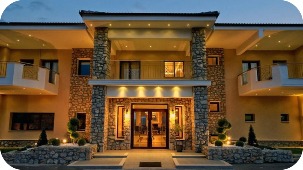 Boutique hotel entrance with stone pillars, soft lighting and a symmetrical layout that enhances its elegant facade.