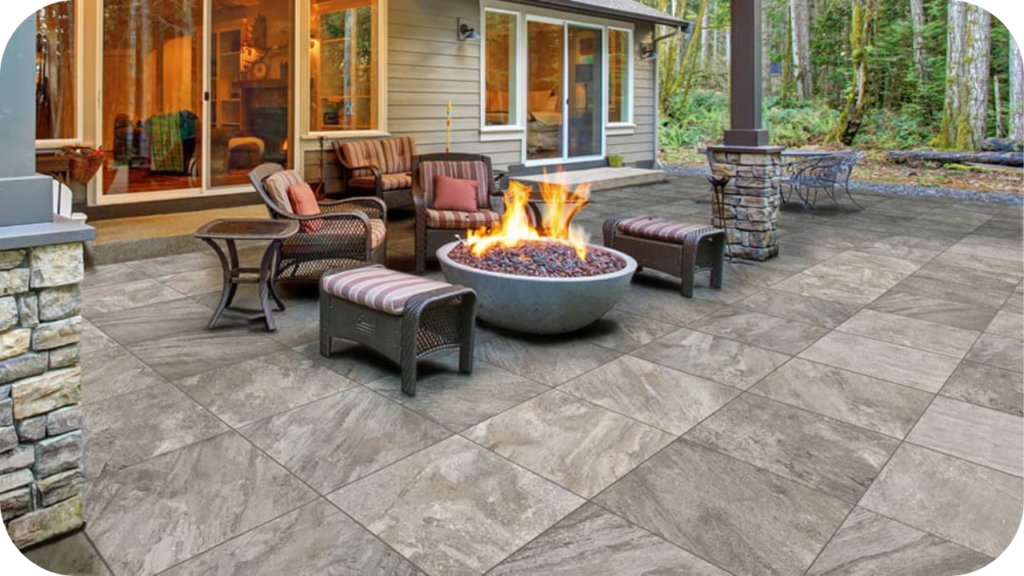 Modern outdoor patio with quartzite pavers, cosy seating, and a round fire pit creating a warm and inviting entertainment space among the trees.