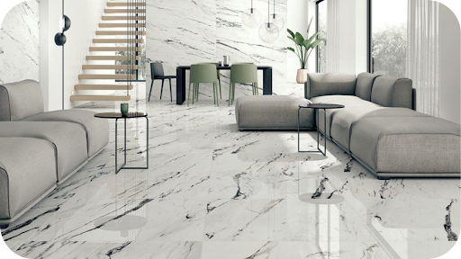Luxury living room with white marble floors and walls, paired with modern grey sofas and dining area, showcasing elegance from a marble supplier in Melbourne.