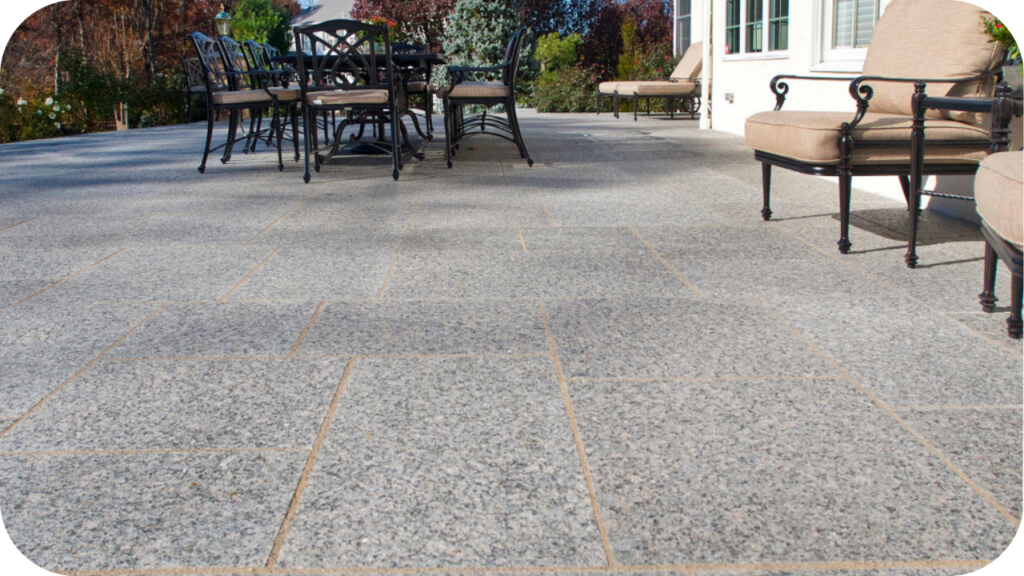 Granite pavers used in a patio with outdoor chairs and table, showcasing strength and style for residential entertainment and garden areas.
