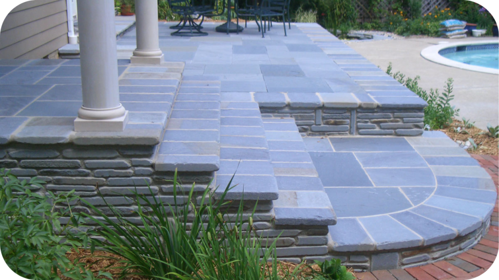 Bluestone pavers used on patio and steps near a pool, paired with stone risers for a refined and practical finish.
