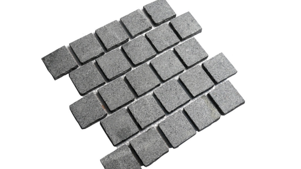 Close-up of grey granite cobblestone tiles arranged in a grid pattern, showing texture and natural stone variation.