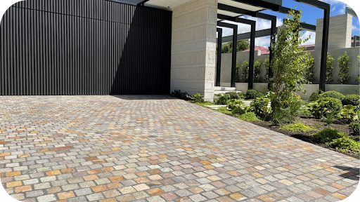 Wide driveway paved with porphyry cobblestone pavers leading to a modern home, showing durable driveway paving suited to Australian conditions.
