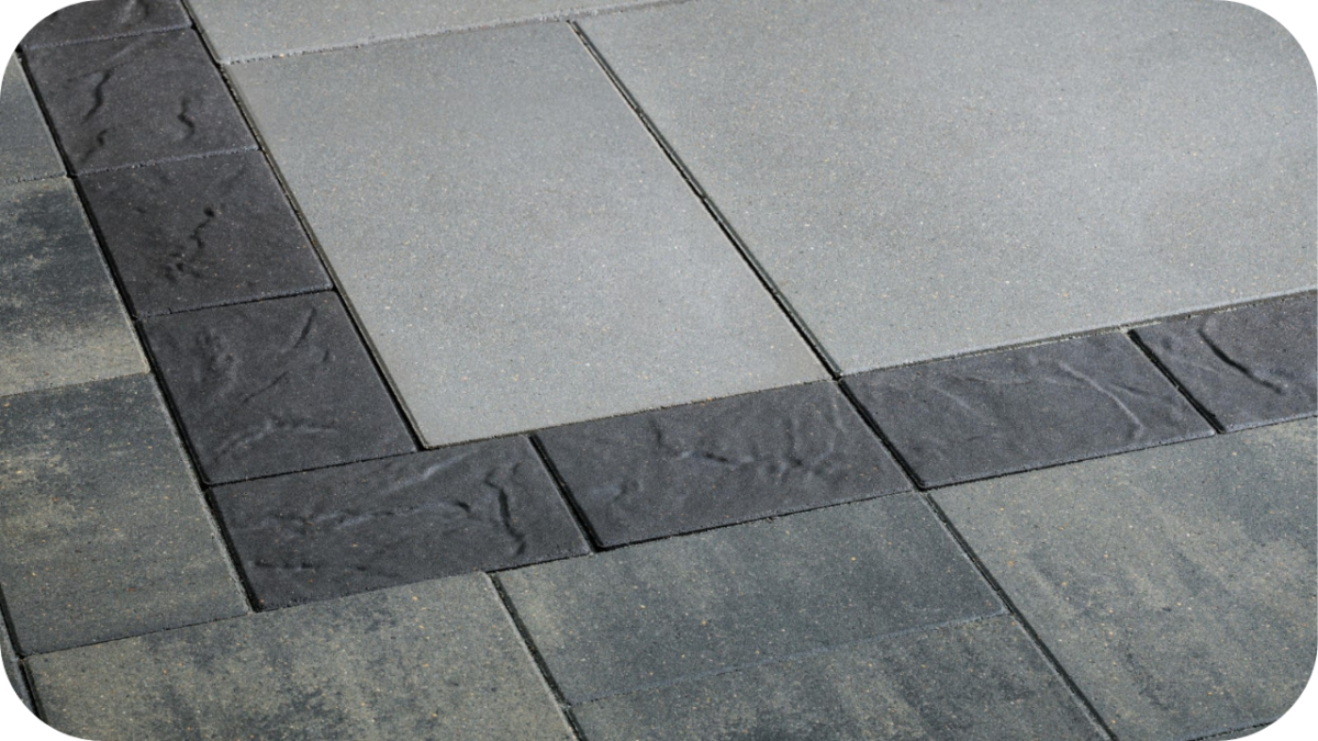 Modern outdoor paving design featuring smooth grey pavers framed by textured charcoal edging, creating a clean geometric layout for contemporary landscaping.