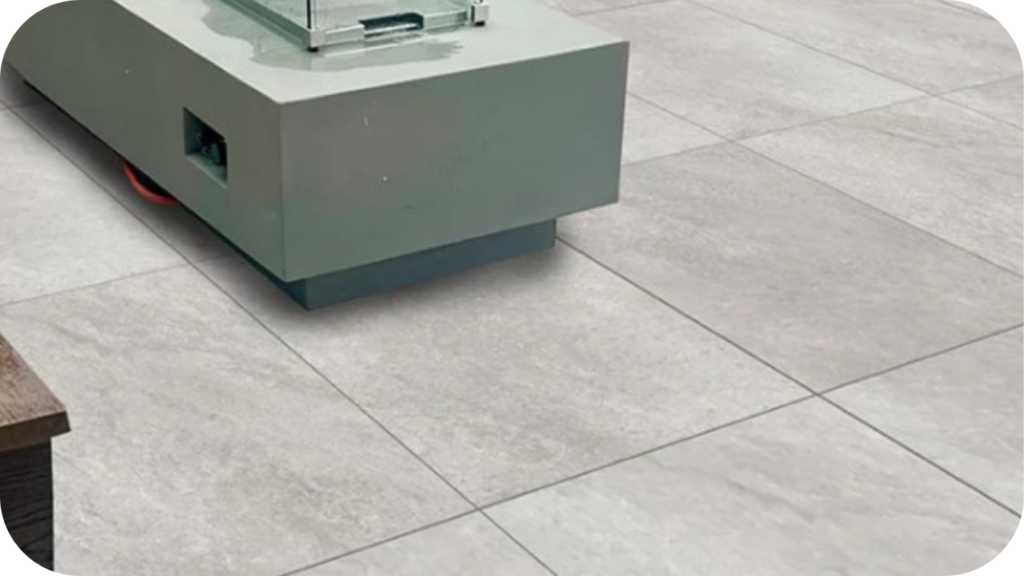  Light grey stone pavers arranged in a clean square layout beneath a modern outdoor bench, highlighting a sleek contemporary paving finish for outdoor areas.